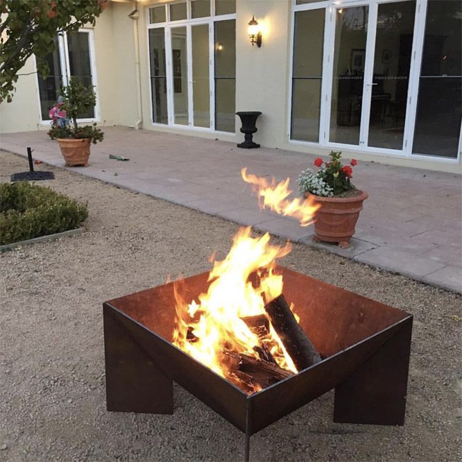 Large Welded Fire Pit With Roaring Fire In A Courtyard