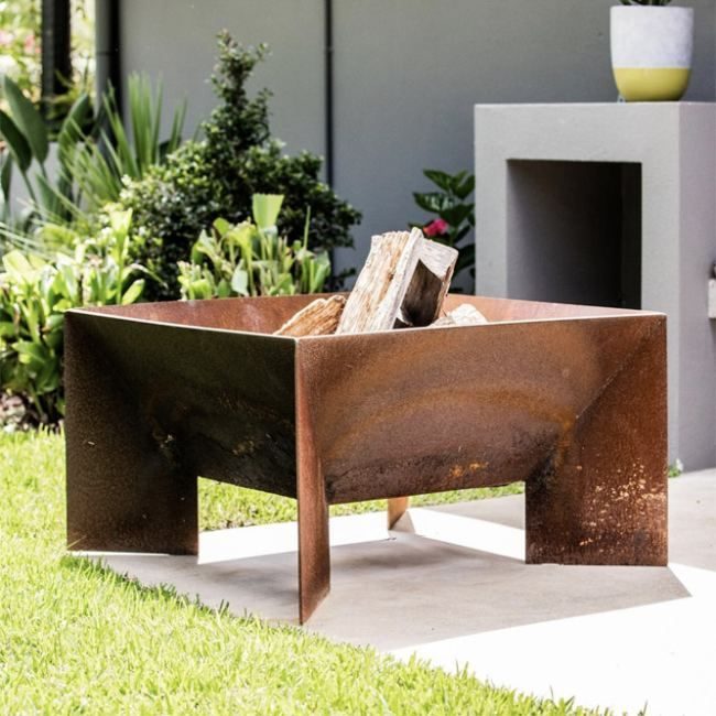 Large Welded Fire Pit With Firewood In Courtyard