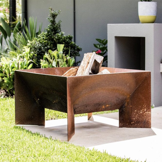 Large Welded Fire Pit With Firewood In Courtyard