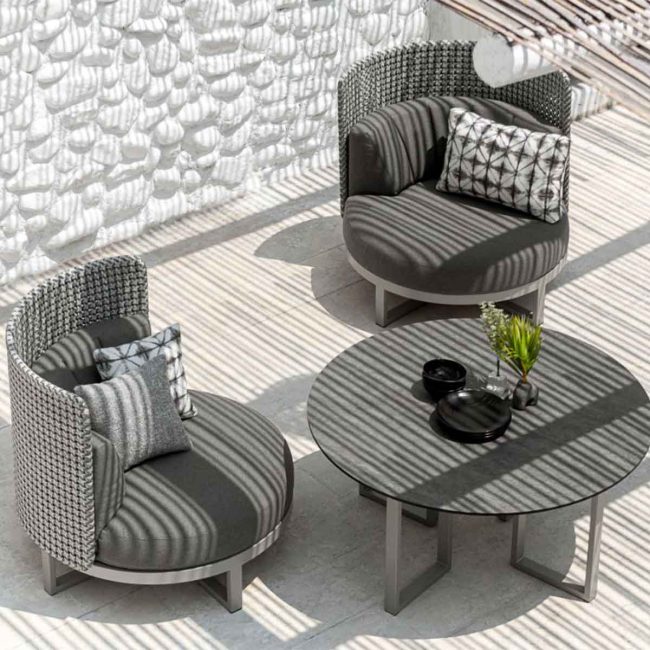 commercial-outdoor-lounge-chairs-circle-high-back commercial outdoor sofa setting with two 1-seaters in dark grey cushion and back, rope weave, and round coffee table in texture HPL top
