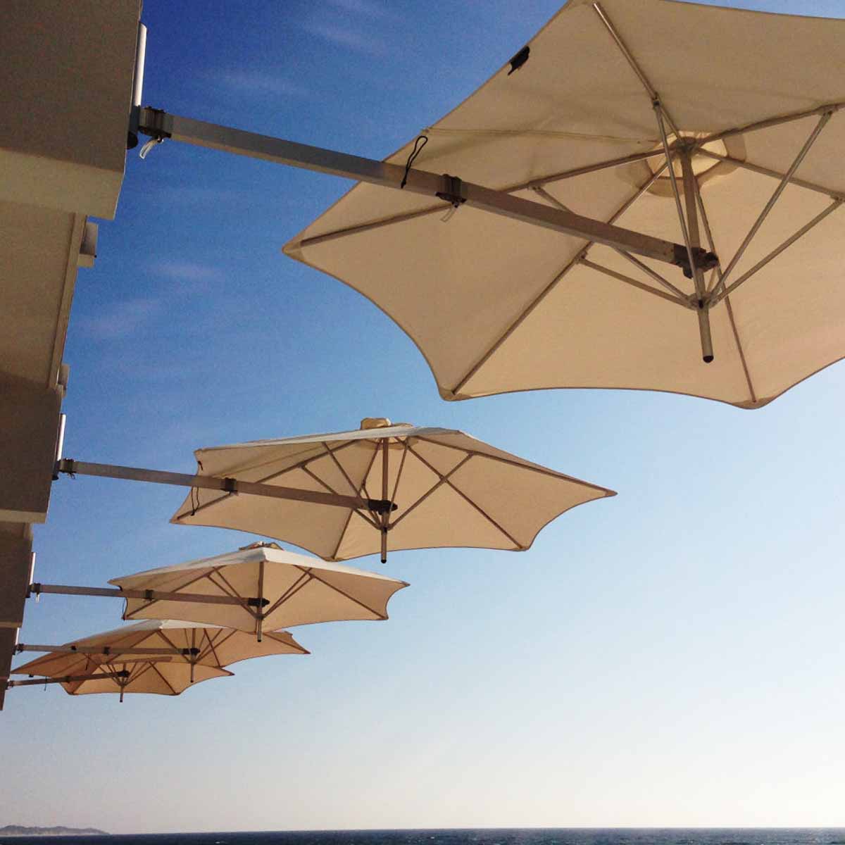 four commercial wall mounted outdoor umbrellas blocking sun